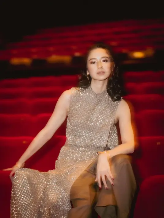 Premiere look dari Laura Basuki. Ia tampil memesona dengan outfit tanpa lengan dan riasan wajah yang glowing, dan rambutnya dikeriting ikal. [Foto: Instagram/laurabas]