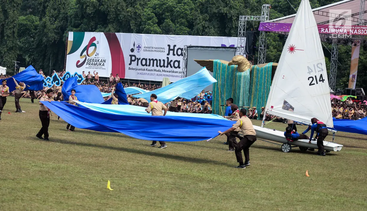 Sejumlah peserta beraksi dalam pembukaan Raimuna Nasional XI di Bumi Perkemahan Cibubur, Jakarta, Senin (14/8). Acara ini diikuti 15.000 Pramuka usia 16-25 tahun dari 34 provinsi dan 514 kota/kabupaten dari seluruh Indonesia. (Liputan6.com/Faizal Fanani)