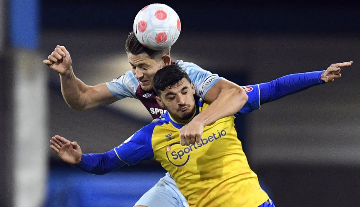 <p>Pemain Burnley James Tarkowski (kiri) berebut bola dengan pemain Southampton Armando Broja (kanan) pada pertandingan Liga Inggris di Turf Moor, Burnley, Inggris, 21 April 2022. Burnley menang 2-0. (Oli SCARFF/AFP)</p>