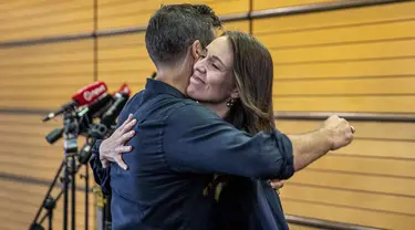 Perdana Menteri Selandia Baru Jacinda Ardern (kanan) memeluk tunangannya Clark Gayford setelah mengumumkan pengunduran dirinya pada konferensi pers di Napier, Selandia Baru, Kamis (19/1/2023). Sambil menahan air mata, Ardern mengatakan kepada wartawan bahwa 7 Februari akan menjadi miliknya hari terakhir di kantor. (Mark MItchell/New Zealand Herald via AP)