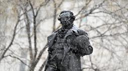 Hujan salju turun di atas patung pelukis Spanyol Francisco de Goya oleh pematung Mariano Benlliure di pusat kota Madrid (7/1/2021). Badan cuaca Aemet memperkirakan akan menjadi salah satu yang paling bersalju dalam beberapa tahun terakhir. (AFP/Gabriel Bouys)