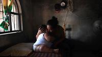 Luis Gonzales mencium ibunya, Isabel Pantoja  di rumah mereka di Tecoman, negara bagian Colima, Meksiko (8/11). Luis Gonzales adalah bayi penderita obesitas yang memiliki berat badan 28 Kg. (AFP Photo/Pedro Pardo)