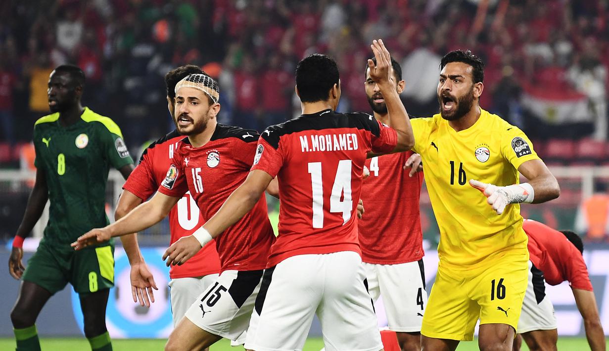 Kiper Mesir, Mohamed Abogabal (kanan) bersama rekan setim merayakan keberhasilan menggagalkan tendangan penalti striker Senegal, Sadio Mane dalam laga final Piala Afrika 2021 di Stade d'Olembe, Yaounde, Kamerun (6/2/2022). (AFP/Kenzo Tribouillard)