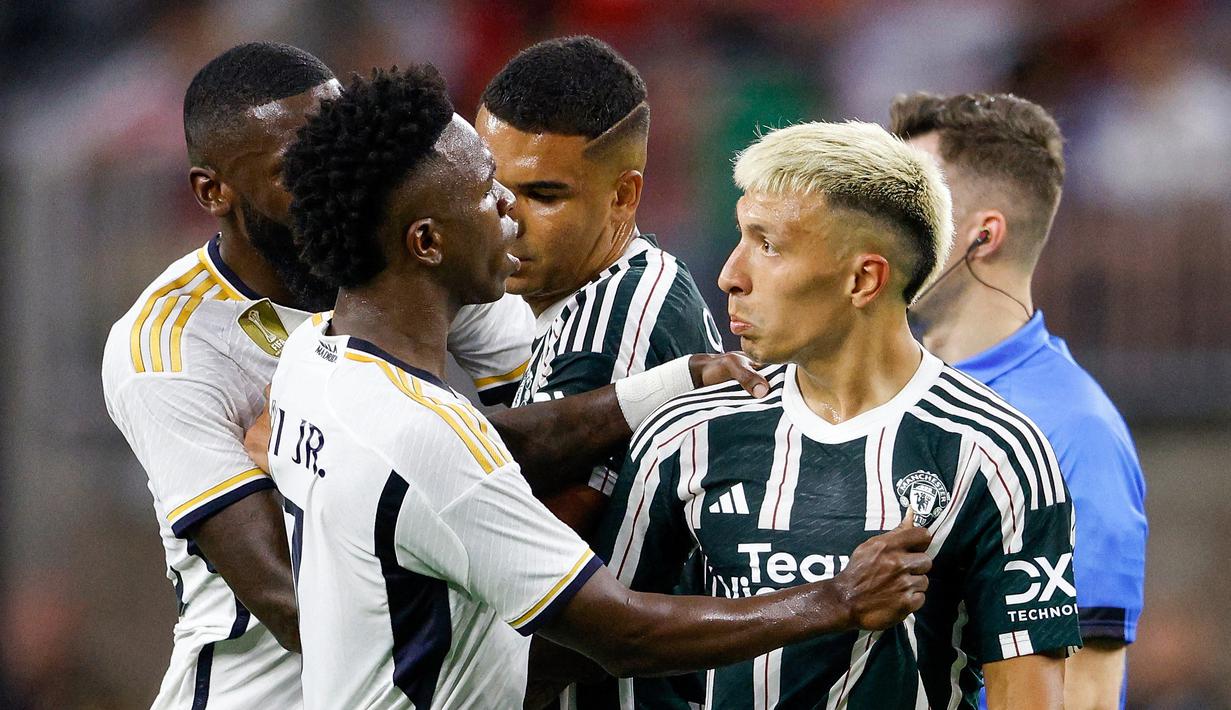 Pemain Real Madrid, Vinicius Jr (kiri) melakukan protes terhadap pemain MU, Lisandro Martinez (kanan), dalam pertandingan pramusim Soccer Champions Tour 2023 yang berlangsung di NRG Stadium, Houston, Kamis (27/7/23). Protes tersebut dilakukan karena Martinez melakukan pelanggaran keras berupa tekel dengan kedua kakinya terhadap Jude Bellingham di menit ke-42. (AFP/Getty Images/Tim Warner)