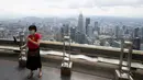 Seorang turis dengan mengenakan masker berswafoto saat mengunjungi dek obseravsi di Menara Kuala Lumpur di Kuala Lumpur, Rabu (1/7/2020). Malaysia memasuki pelonggaran Perintah Kontrol Gerakan (MCO) setelah tiga bulan pembatasan karena virus corona Covid-19. (AP Photo/Vincent Thian)
