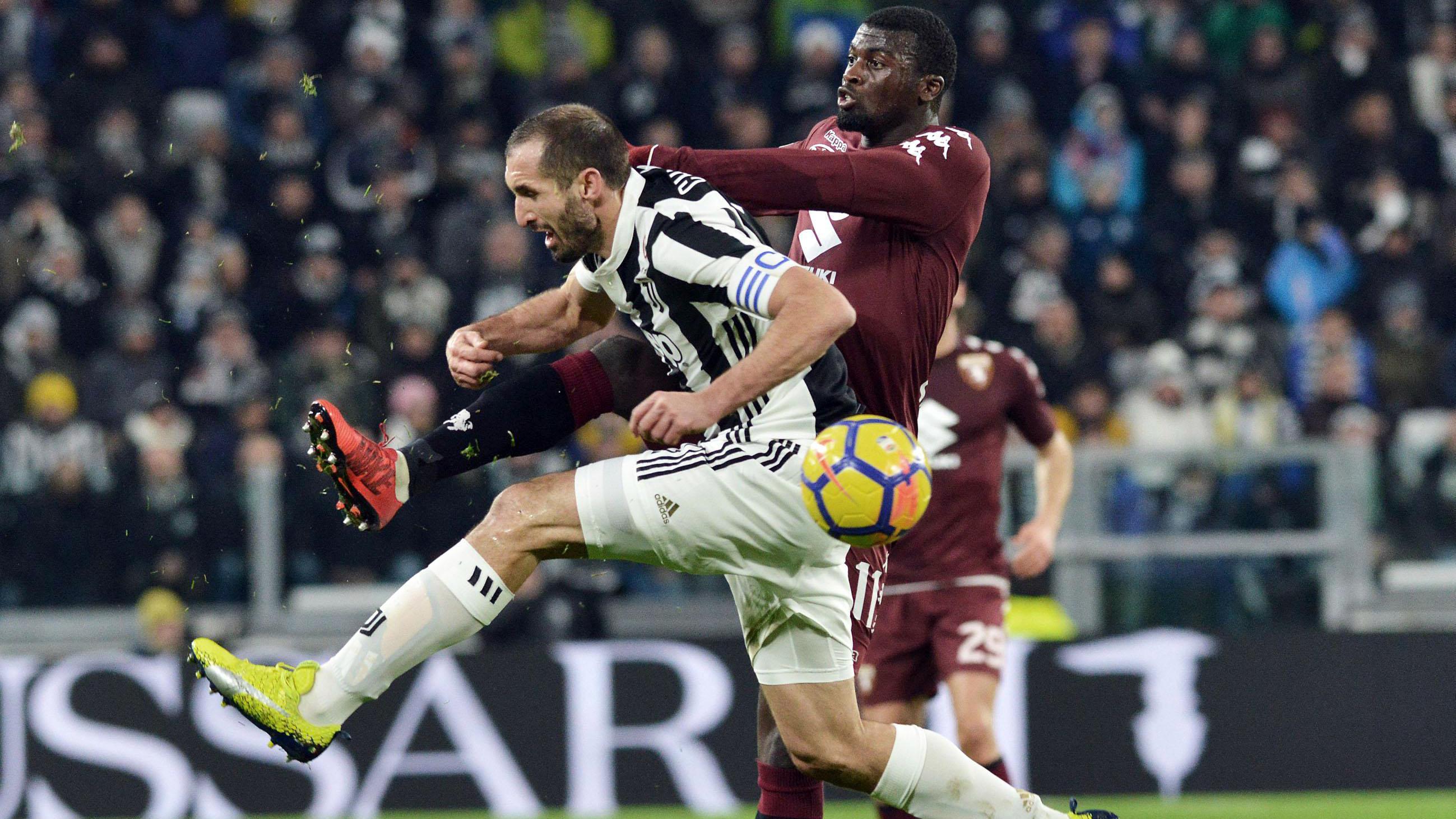 Duel pemain Juventus, Giorgio Chiellini (kiri) dan pemain Torino, M'Baye Niang pada laga perempatfinal Coppa Italia di Allianz Stadium, Turin, Italia, (3/1/2018). Juventus menang 2-0. (Alessandro Di Marco/ANSA via AP)