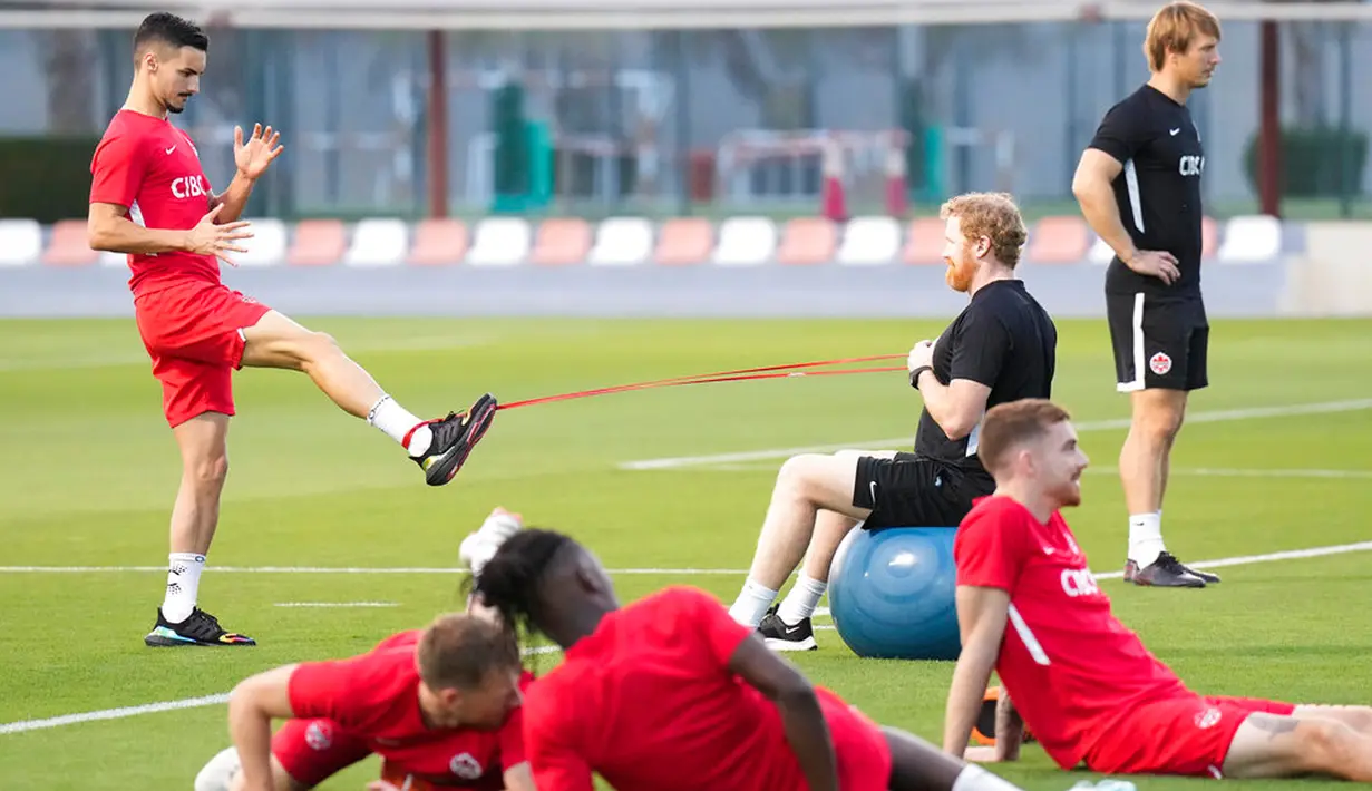 Pemain Kanada Stephen Eustaquio (kiri belakang) melakukan peregangan saat sesi latihan di Doha, Qatar, 28 November 2022. Kanada akan menghadapi Maroko dalam pertandingan Piala Dunia 2022 pada 1 Desember 2022. (Nathan Denette/The Canadian Press via AP)