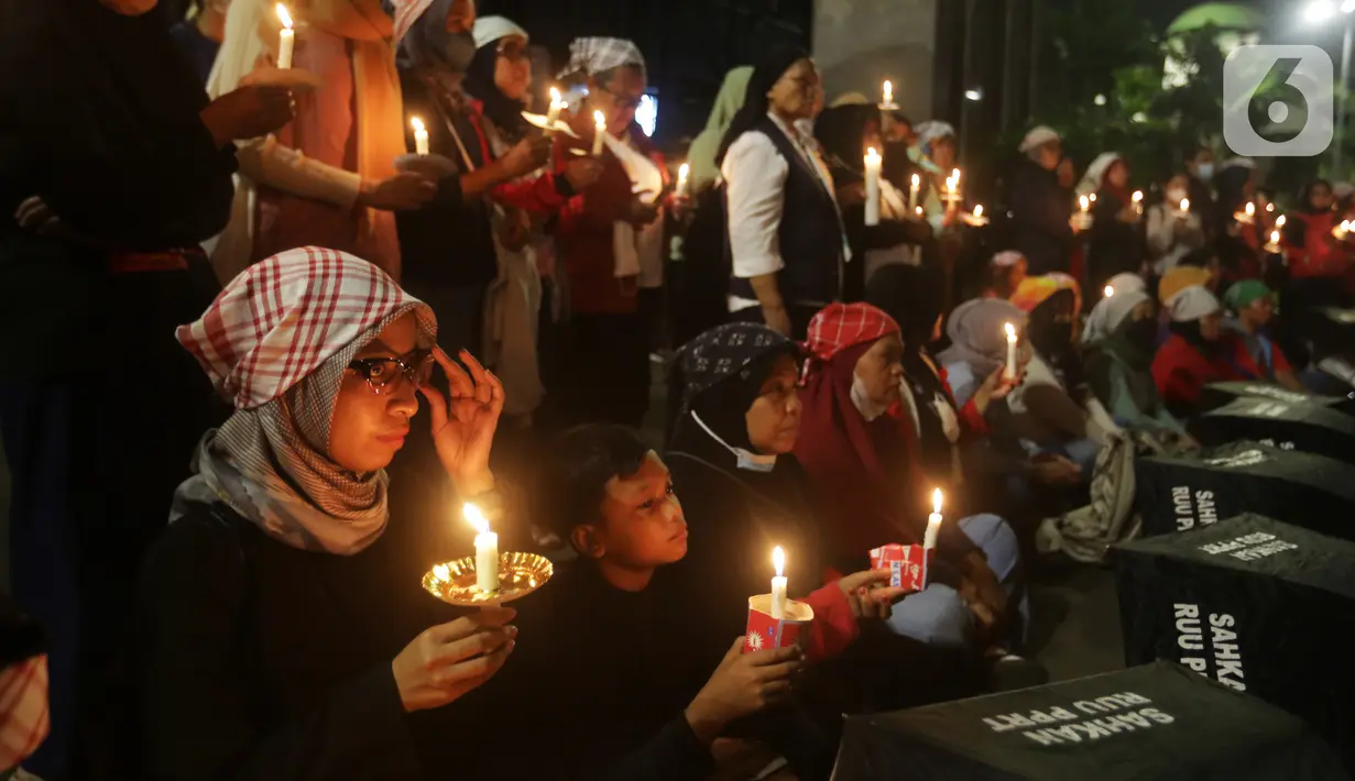Massa menggelar aksi dengan membawa lilin dan doa bersama lintas agama di depan Gedung DPR, Jakarta, Kamis (16/3/2023). Dalam aksinya, mereka menuntut agar pimpinan DPR menetapkan RUU PPRT sebagai RUU INISIATIF DPR di Rapat Paripurna pada Selasa, 21 Maret 2023 mendatang. (Liputan6.com/Johan Tallo)