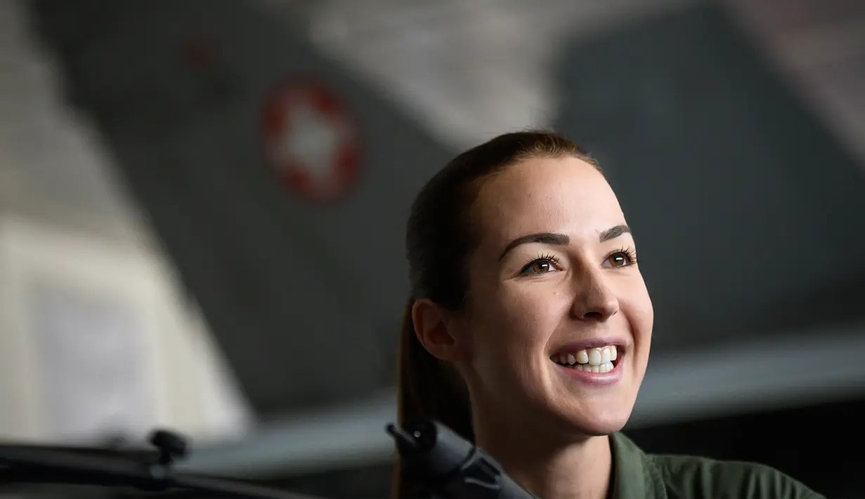 Fanny Chollet tersenyum selama konferensi pers di Pangkalan Udara Payerne, Swiss, (19/12). Fanny Chollet 28 tahun yang dijuluki 'Shotty' merupakan pilot jet tempur perempuan pertama Swiss. (AFP Photo/Fabrice Coffrini)