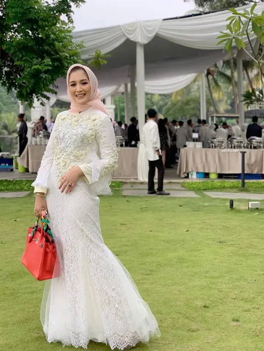 Dress bersiluet duyung warna putih beri kesan anggun pada penampilan Dine Mutiara.  [Foto: IG/dine.pearl].