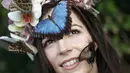Seorang model bernama, Jessie May Smart mengenakan mahkota bunga yang dihinggapi kupu-kupu berpose di RHS Wisley di Wisley, Inggris, (13/1). Acara tersebut merupakan bagian dari pembukaan "Butterflies in the Glasshouse". (AFP/Adrian Dennis)