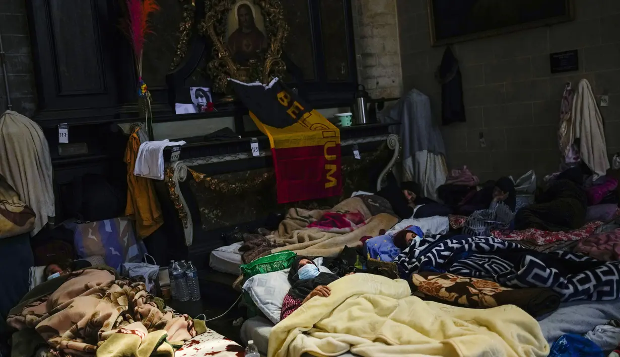 Para perempuan mogok makan beristirahat saat bersama yang lain menempati gereja Saint-Jean-Baptiste-au-Beguinage di Brussel, Senin (7/6/2021). Puluhan migran tanpa surat resmi dan yang telah menduduki gereja sejak Februari lalu telah memulai mogok makan sejak 23 Mei 2021. (AP Photo/Francisco Seco)
