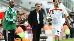 Iran dan Nigeria harus puas bermain imbang 0-0. Tampak, pelatih Nigeria, Stephen Keshi (kiri) terlihat memberikan arahan kepada timnya saat berlaga di babak penyisihan Piala Dunia Grup F, Baixada Arena, Brasil, (17/6/2014). (AFP PHOTO/Jewel Samad)