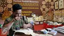 Seorang pengrajin memperlihatkan cara membuat wayang kulit di Festival Naskah Nusantara, Perpustakaan Nasional, Jakarta (14/9/2015). (Liputan6.com/ Gempur M Surya)