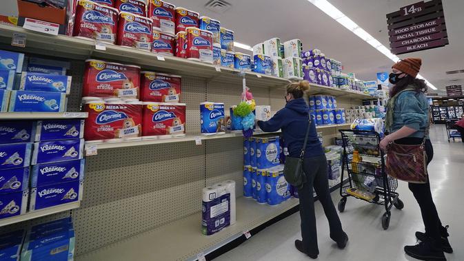 Seorang perempuan membeli tisu toilet di sebuah pasar di Mount Lebanon, negara bagian Pennsylvania, AS pada 17 November 2020. Lonjakan kasus COVID-19 di AS membuat orang kembali ke toko untuk menimbun lagi, meninggalkan rak kosong dan memaksa pengecer membatasi pembelian (AP/Gene J. Puskar)