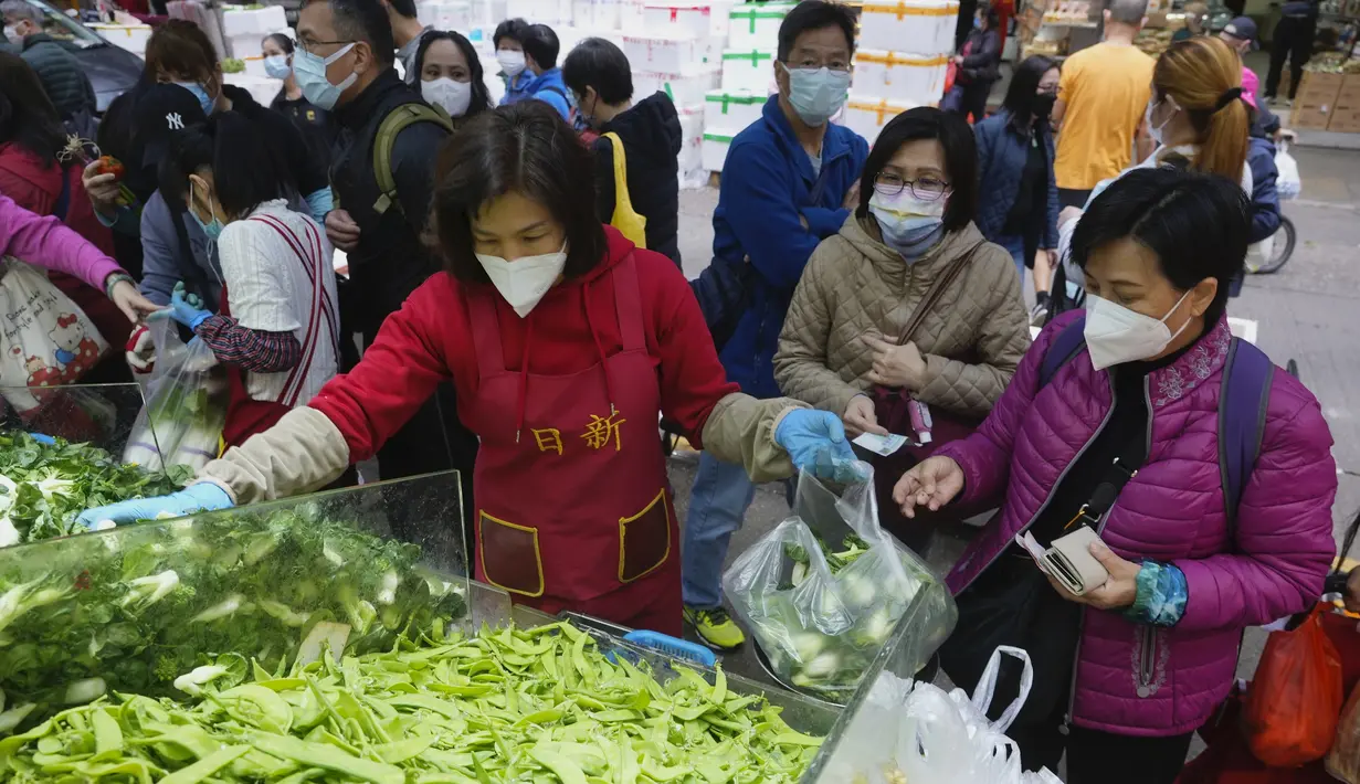 Pelanggan mengenakan masker, membeli sayuran segar di toko pasar basah di Hong Kong, Rabu, 9 Februari 2022. Hong Kong mengumumkan pembatasan virus corona baru yang ketat yang diperparah dengan semakin minimnya pasokan sayuran dikarenakan pengemudi truk yang positif COVID-19. (AP Photo/Vincent Yu)
