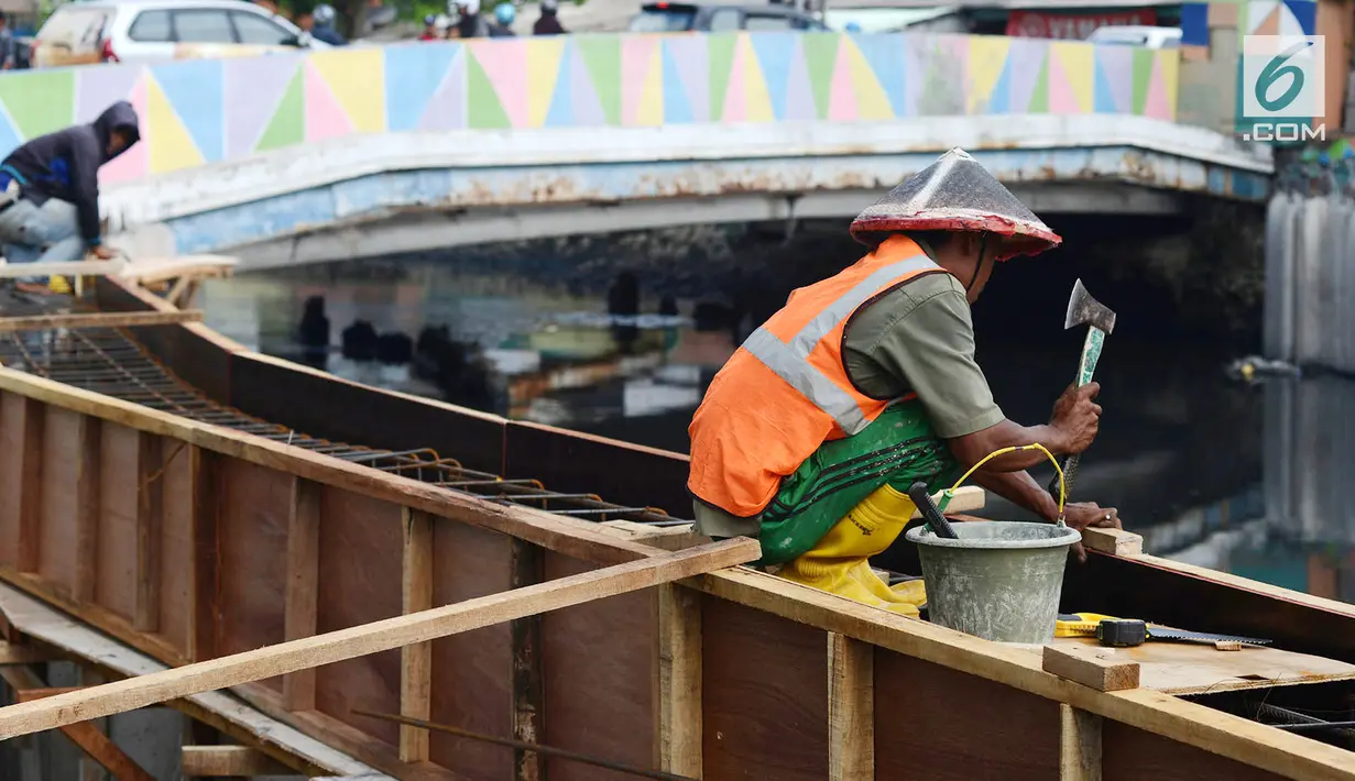 Aktivitas pekerja saat memasang turap atau sheetpile Kali Item, Jakarta, Rabu (2/1). Turap sepanjang 1.900 meter pada sisi kanan dan kiri kali untuk mengantisipasi genangan dan banjir di kawasan tersebut pada musim hujan. (Merdeka.com/Imam Buhori)