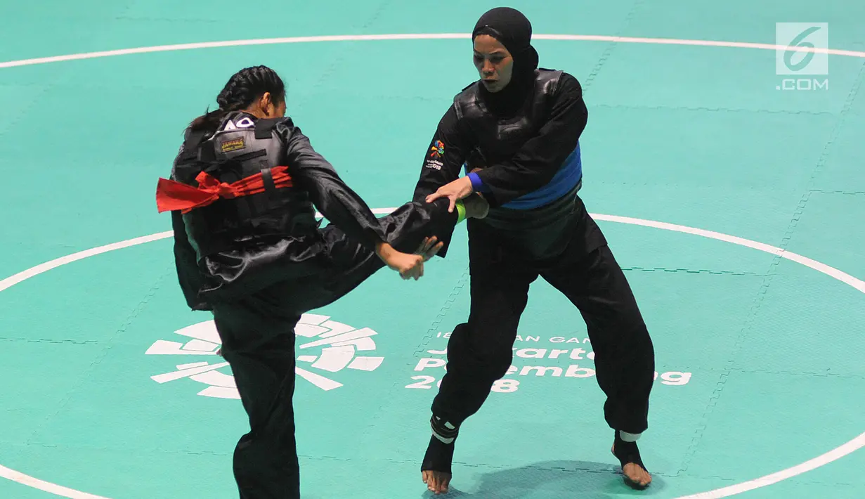 Pesilat Indonesia, Sarah Tria Monita (biru) bertanding melawan Nong Oy Vongphakdy (merah) asal Laos dalam babak final Kelas C Putri Asian Games 2018 di Jakarta, Senin (27/8). Sarah menang dan mendapatkan medali emas. (Merdeka.com/Arie Basuki)