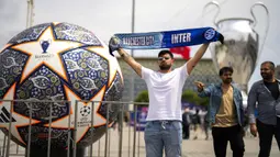 Seorang pengunjung berpose dengan membentangkan syal yang bergambar Inter Milan dan Manchester City di Istanbul, Turki, Kamis (8/6/2023). Laga final yang mempertemukan Inter Milan melawan Manchester City akan berlangsung di Atatürk Olympic Stadium, Istanbul, Turki, Minggu (9/6/2023) dini hari WIB. (AP Photo/Francisco Seco)