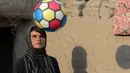 Foto pada 20 Maret 2018, perempuan Afghanistan Sitara Wafadar yang menyamar sebagai laki-laki bermain bola di rumahnya, Provinsi Nangarhar. Tradisi "bacha pochi" sudah mengakar di Afghanistan yang lebih menghargai anak laki-laki. (NOORULLAH SHIRZADA/AFP)
