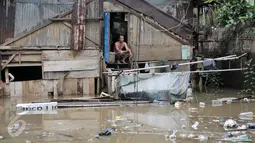 Warga menunggu banjir surut di kawasan Cawang, Jakarta, Selasa (21/2). Akibat curah hujan yang tinggi sejumlah pemukiman di bantaran Ciliwung kelurahan Cawang dan Rawajati terendam banjir. (Liputan6.com/Yoppy Renato)