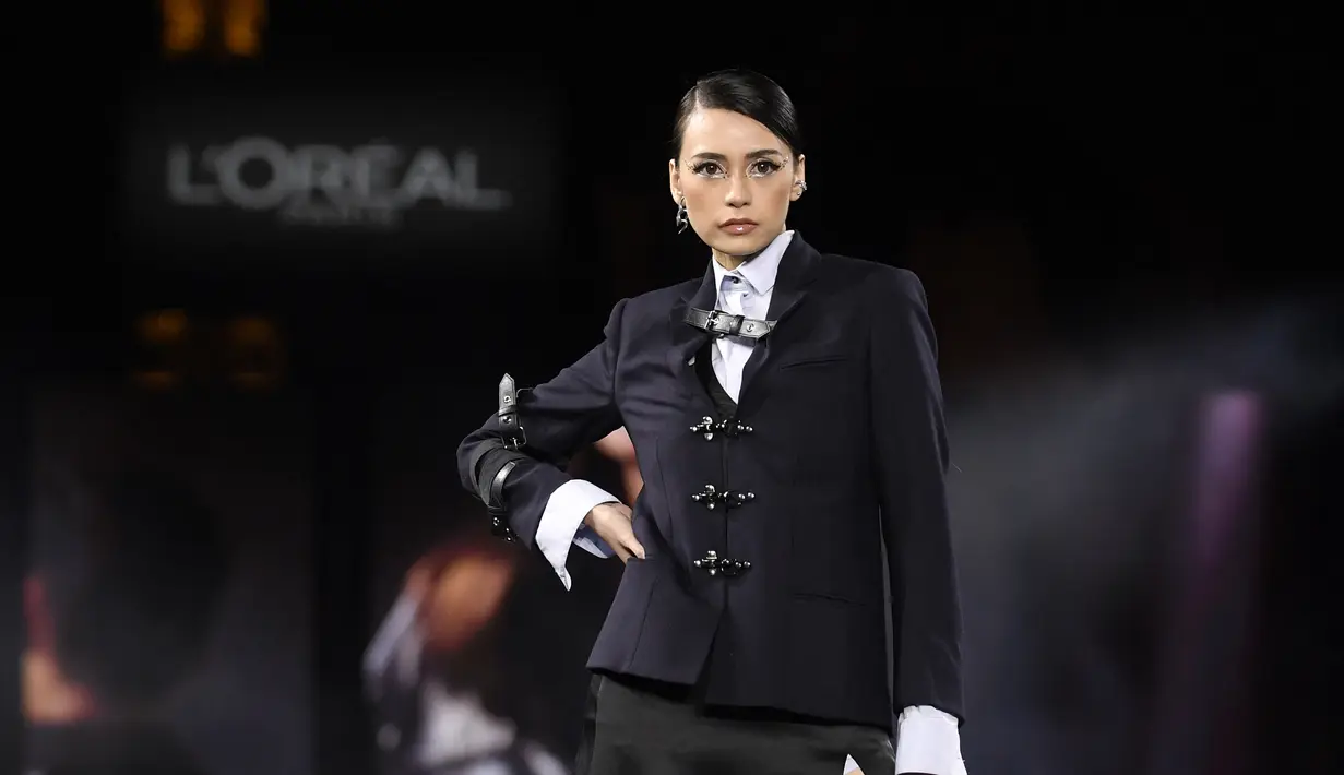 Tamara Dai berpose di catwalk mempersembahkan kreasi untuk L'Oreal selama peragaan busana Spring-Summer 2023 sebagai bagian dari Paris Womenswear Fashion Week, di Paris, pada 2 Oktober 2022. Perempuan yang dikenal sebagai model itu tampil menawan dengan busana bergaya androgini. (AFP/Julien De Rosa)