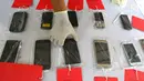 Polisi menunjukkan barang bukti handphone di Mapolsek Benda, Tangerang, Banten, Senin (19/11). Polisi menangkap otak pelaku kejahatan spesialis handphone dan tiga tersangka lainnya. (Liputan6.com/Fery Pradolo)