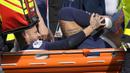 Pemain Paris Saint-Germain (PSG), Neymar, meringis kesakitan saat ditandu keluar lapangan setelah mengalami cedera pada laga Liga Prancis di Stadion Parc des Princes, Minggu (19/2/2023). Neymar mengalami cedera pergelangan kaki setelah beradu dengan pemain Lille, Benjamin Andre. (AP Photo/Christophe Ena)