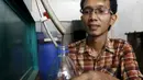 Hamidi saat menampung cairan hasil dari olahan pembakaran sampah plastik di bengkel kerjanya dekat TPA Rawa Kucing, Tangerang, (17/3). Dengan hasil temuannya ini, Hamidi dapat membuat bahan bakar yang hemat energi. (REUTERS / Beawiharta)