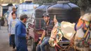 Warga Palestina berkumpul di samping gerobak yang ditarik keledai yang berisi tangki air untuk dijual, karena air minum dan bahan bakar semakin langka, di Khan Yunis di Jalur Gaza Selatan pada 30 Oktober 2023. (MAHMUD HAMS/AFP)