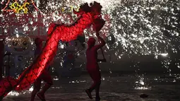 Penari melakukan tarian naga di sebuah taman pada hari keempat Tahun Baru Imlek di Beijing (8/2). China menandai kedatangan Tahun Babi dengan liburan Festival Musim Semi selama seminggu.  (AFP Photo/Greg Baker)