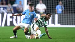 Pemain Glasgow Celtic,  Tomoki Iwata, berebut bola dengan pemain Manchester City, Jacob Wright, pada laga uji coba di Stadion Kenan Memorial, Rabu (24/7/2024). (AFP/Grant Halverson)