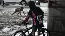Seorang anak laki-laki bermain di air banjir yang disebabkan oleh badai tropis parah Conson di kota Quezon, Filipina (8/9/2021).  Topan Conson menghantam Filipina timur, menyebabkan pemadaman listrik, penangguhan pekerjaan di kantor-kantor pemerintah. (AP Photo/Aaron Favila)