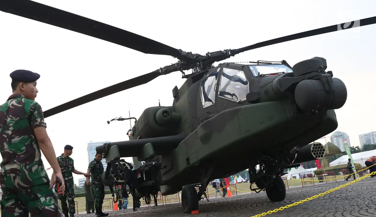 Anggota TNI berada di sisi helikopter Apache yang dipamerkan pada pameran Alat Utama Sistem Persenjataan TNI di Kawasan Monas, Jakarta, Kamis (27/9). TNI memiliki delapan helikopter Apache AH 64E buatan Amerika Serikat. (Liputan6.com/Helmi Fithriansyah)