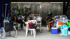 Pasien dan kerabat terduga Covid-19 beristirahat di tempat parkir yang diubah menjadi bangsal di luar rumah sakit di kota Binan, provinsi Laguna, Manila, di tengah rekor infeksi yang dipicu oleh varian Delta yang sangat menular pada Senin (6/9/2021). (Photo by Maria Tan / AFP)
