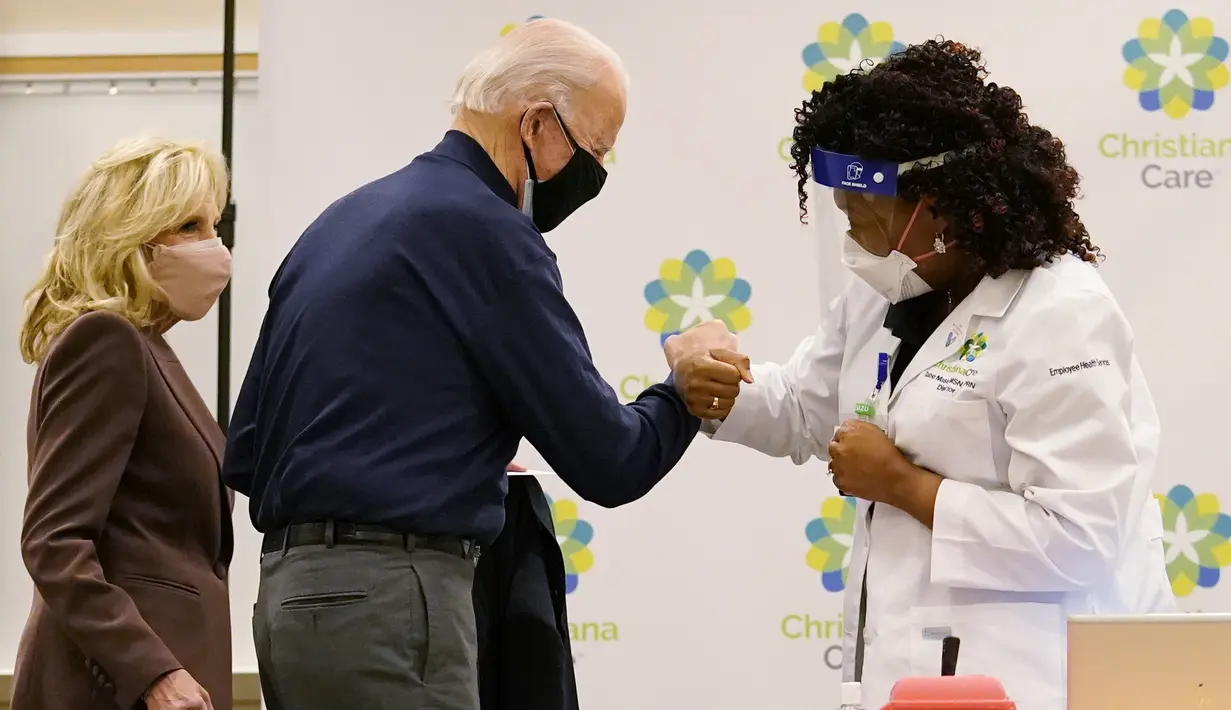 Presiden AS terpilih, Joe Biden melakukan fist bump setelah menerima dosis pertama vaksin virus corona Pfizer-BioNTech di Rumah Sakit Christiana di Newark, Delaware, Senin (21/12/2020). Istrinya, Jill Biden, menerima rangkaian vaksin pertamanya pada hari sebelumnya. (AP Photo/Carolyn Kaster)