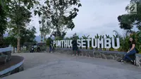 Wisatawan berfoto di tulisan Punthuk Setumbu, Magelang, Jawa Tengah, Jumat (19/10). Bukit Punthuk Setumbu merupakan salah satu spot terbaik untuk menyaksikan sunrise dengan latar Gunung Merapi Merbabu. (Liputan6.com/Herman Zakharia)
