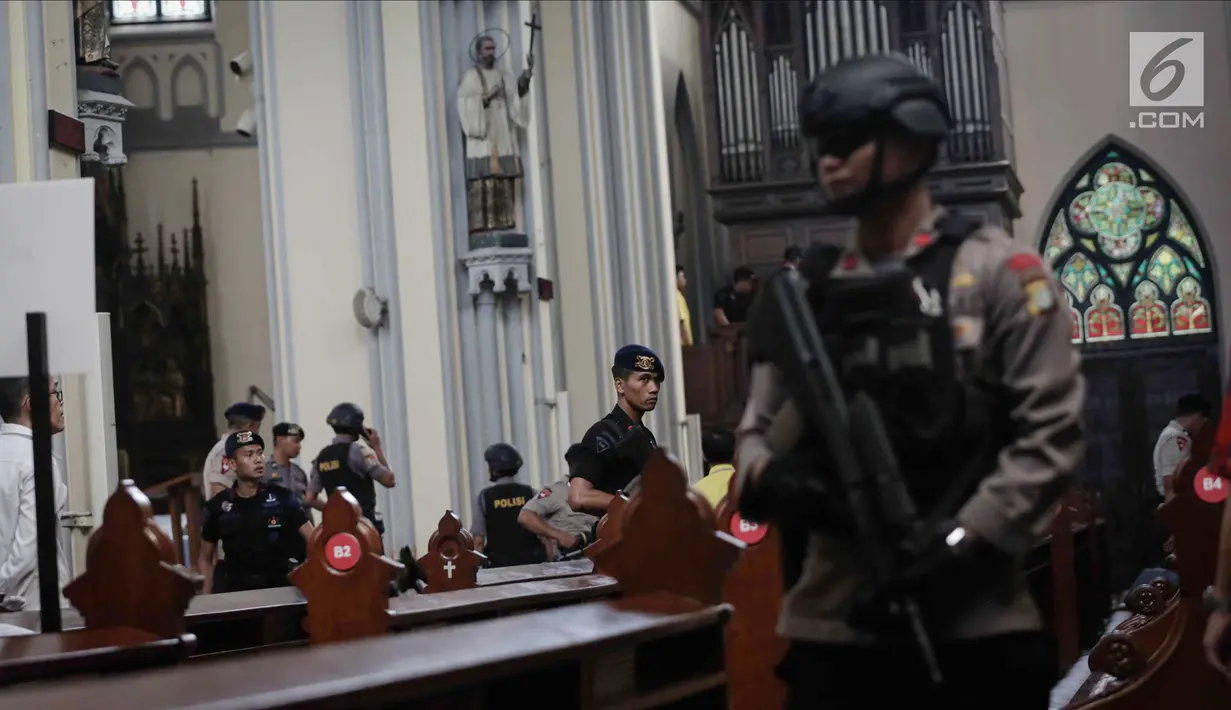 Personel Gegana dan K9 Polda Metro Jaya melakukan penyisiran ketika sterilisasi Gereja Katedral, Jakarta, Minggu (24/12). Sterilisasi di sejumlah gereja ini dilakukan untuk menjamin rasa aman saat menjalankan ibadah Natal. (Liputan6.com/Faizal Fanani)