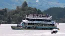 Sebuah kapal mendekati kapal wisata Almirante sesaat sebelum tenggelam di sebuah waduk di Kolombia barat daya, Minggu (25/6). Dilaporkan bahwa kapal yang membawa lebih dari 150 orang itu tenggelam berlangsung kurang dari lima menit. (Juan QUIROZ/AFPP)