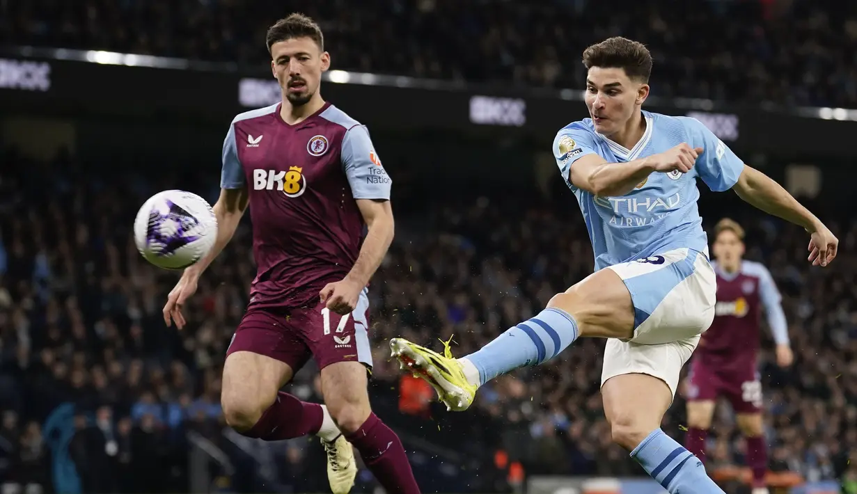 Striker Manchester City, Julian Alvarez (kiri) melepaskan tendangan di samping bek Aston Villa, Clement Lenglet pada laga pekan ke-31 Premier League 2023/2024 di Etihad Stadium, Manchester, Rabu (3/4/2024) malam. (AP Photo/Dave Thompson)