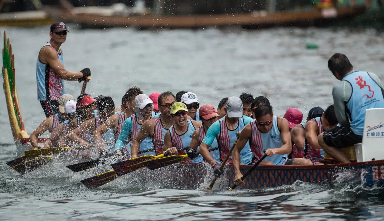 Peserta lomba Festival Perahu Naga atau biasa dikenal Tung Ng Festival berlomba menjadi yang tercepat di Hong Kong, Kamis (9/6). Masing-masing perahu memuat 22 awak pendayung. (Anthony WALLACE/AFP)