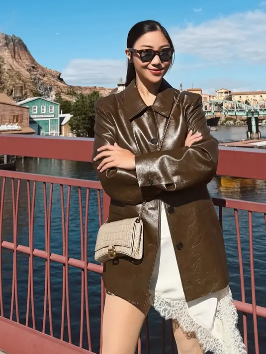 <p>Nona Willy juga mengenakan jaket leather coklat dipadukan dress putih asimetris dengan aksen lace. [@nonawilly16]</p>