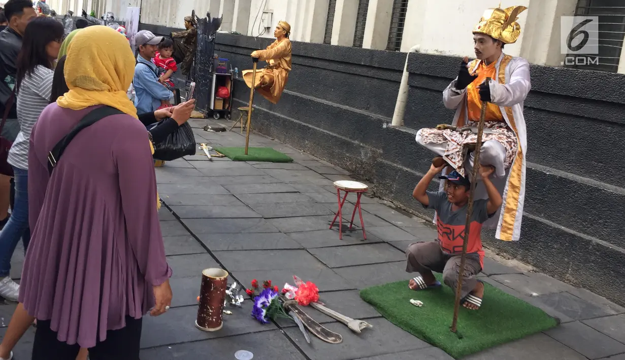 Seorang anak berfoto dengan manusia patung di kawasan Museum Fatahilah, Kota Tua, Jakarta, Jumat (16/2). Wisata kota tua dengan daya tarik bangunan sejarah Jakarta ini dipadati pengunjung yang memanfaatkan masa Imlek 2018. (Liputan6.com/Immanuel Antonius)