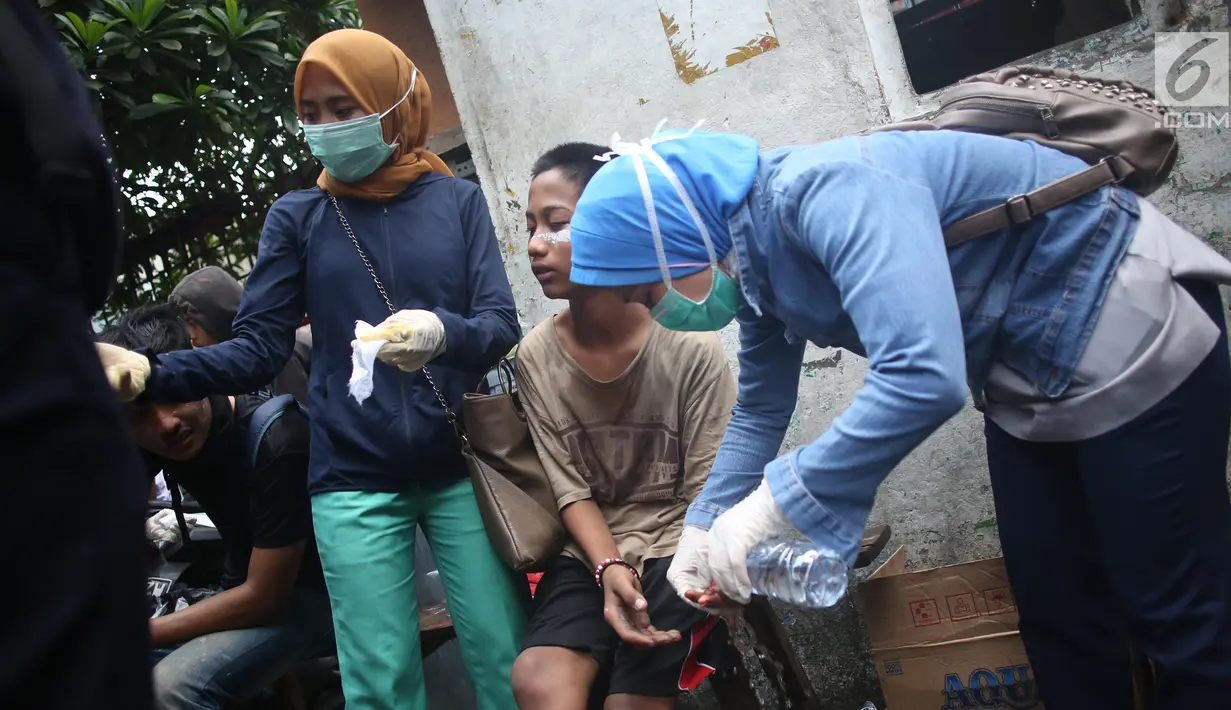 Seorang anak mendapat perawatan setelah terkena gas air mata dalam demonstrasi di belakang Gedung DPR, Palmerah, Jakarta, Rabu (25/9/2019). Polisi menembakkan gas air mata untuk membubarkan pelajar yang berdemonstrasi. (Liputan6.com/Angga Yuniar)