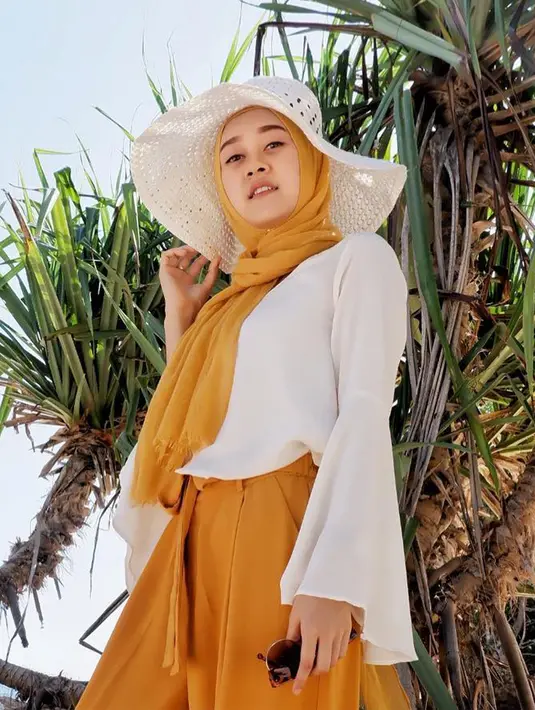 Saat liburan, Ellen tampil dengan hijab panjang berwarna oranye dipadukan dengan celana panjang berwarna seragam dan baju berwarna putih. (Liputan6.com/IG/@ellennitaa)
