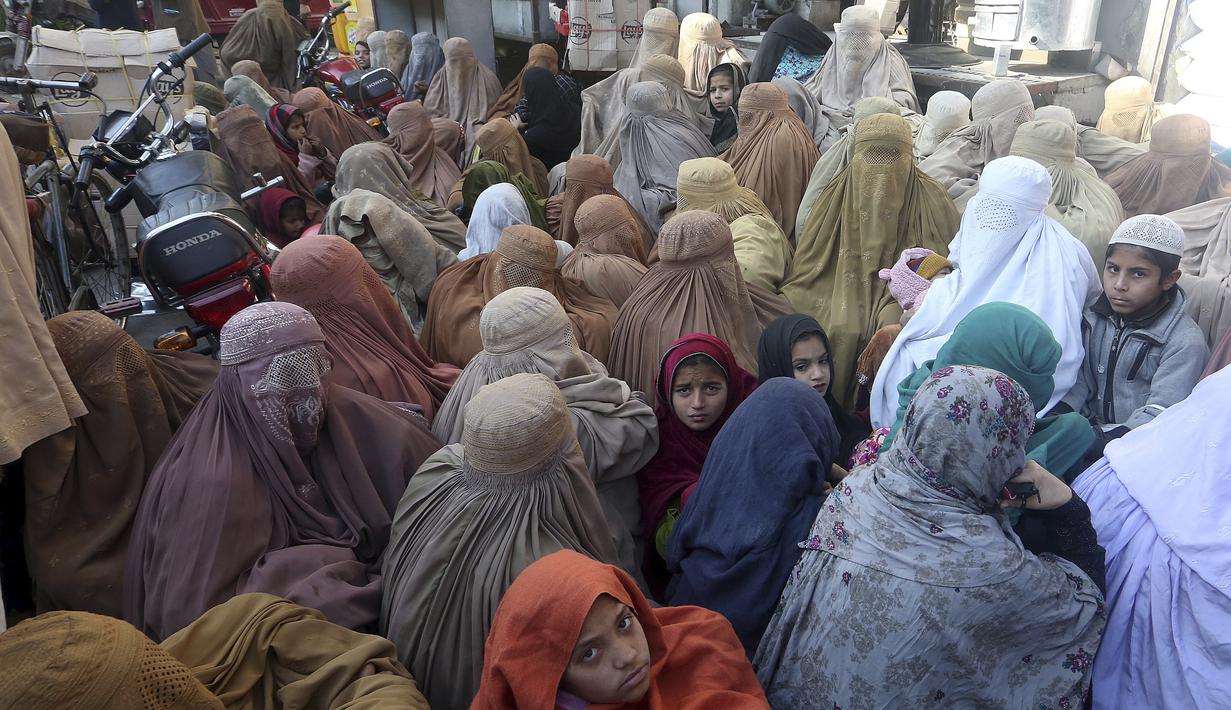 Kaum perempuan menunggu untuk membeli karung tepung terigu bersubsidi dari titik penjualan di Peshawar, Pakistan, Senin, 9 Januari 2023. Orang-orang menderita akibat kenaikan harga tepung terigu di Pakistan baru-baru ini. (AP Photo/Muhammad Sajjad)