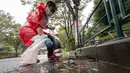 Seorang peserta memungut sampah dari jalan selama tahap Jepang "SpoGOMI World Cup 2023" di mana para tim memungut sampah sebanyak mungkin, di daerah Shinjuku, Tokyo pada tanggal 9 Oktober 2023. (Richard A. Brooks/AFP)