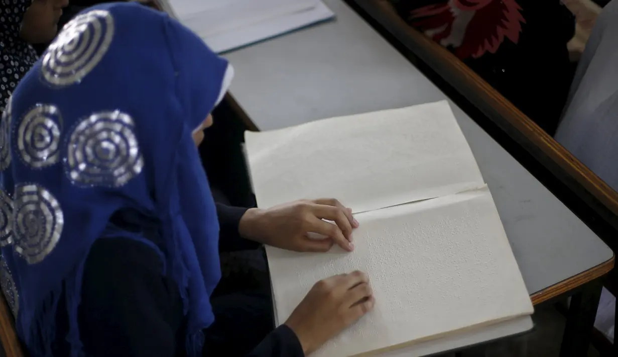 Seorang penyandang tunanetra ketika membaca Alquran versi Braille di Gaza, Palestina, Kamis (18/6). Bulan Ramadan, ribuan warga Palestina, termasuk penyandang tunanetra mendapat pelajaran membaca dan menghafal Alquran secara gratis. (REUTERS/Suhaib Salem)