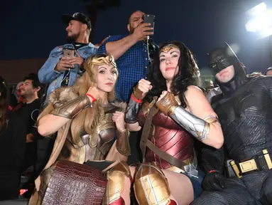 Penggemar mengenakan kostum Batman dan Wonder Woman saat menghadiri pemutaran perdana film Justice League di Dolby Theatre di Hollywood, California (13/11). (AFP Photo/Robyn Beck)