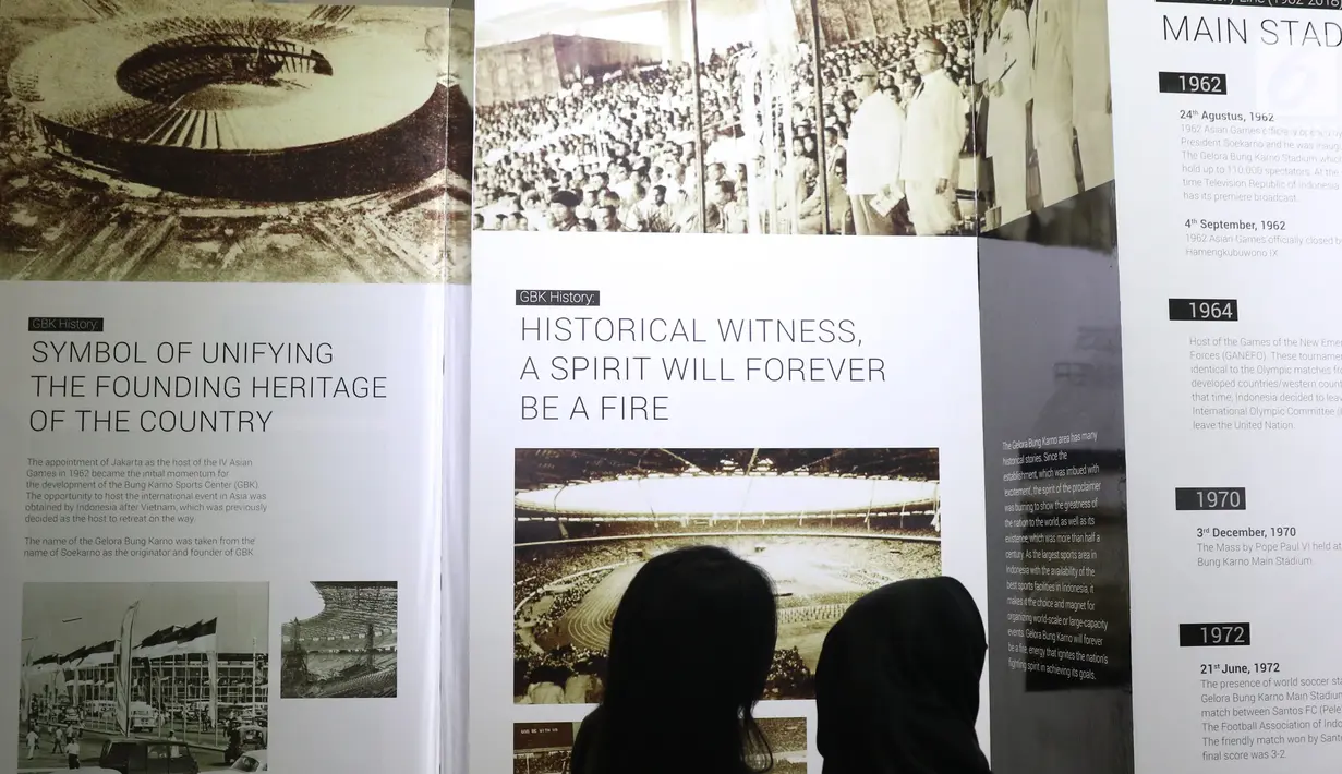 Pengunjung melihat-lihat dokumentasi pembangunan kompleks olahraga Gelora Bung Karno yang dipamerkan di area Stadion GBK, Jakarta, Rabu (29/8). Sejumlah dokumentasi pembangunan stadion dicetak dan bisa dilihat warga. (Liputan6.com/Helmi Fithriansyah)